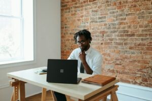 un homme assis à une table devant un ordinateur portable