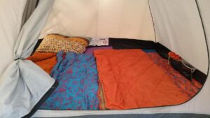 Tente avec des textiles colorés, coussins et sacs, ambiance de camping