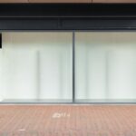 façade de boutique fermée, sol en briques, porte à gauche