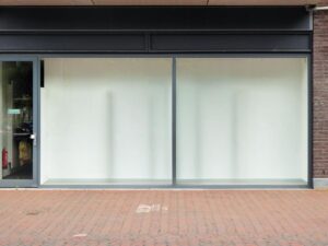 façade de boutique fermée, sol en briques, porte à gauche