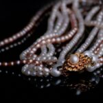 Collier de perles blanches et rosées avec fermoir or sur fond noir